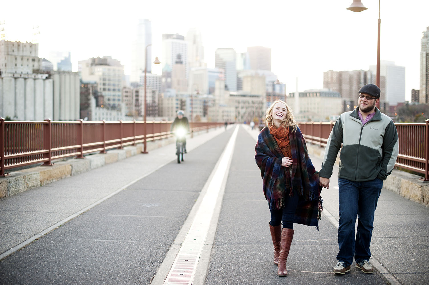 engaged couple walking on the stone arch bridge laughing
