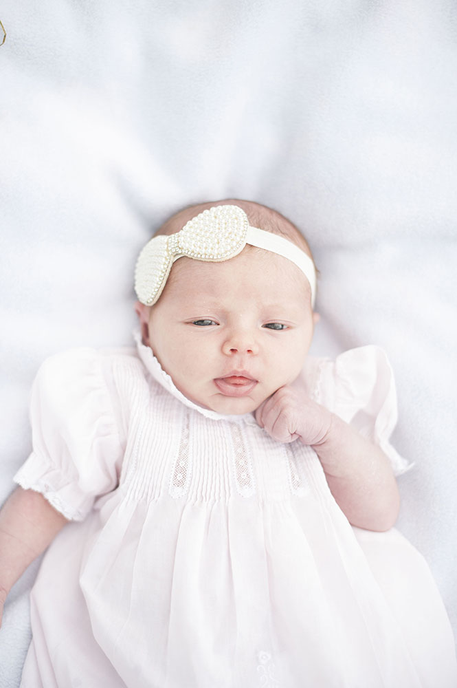 newborn girl with pink dress and bow