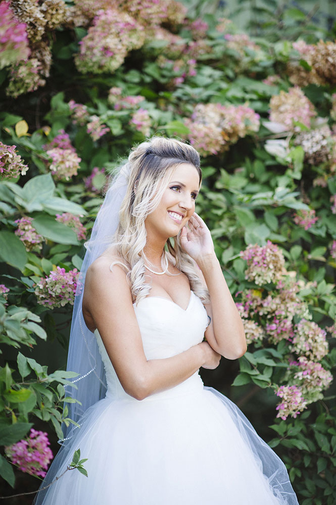 bride in front of hydrangea bush at Camrose HIll