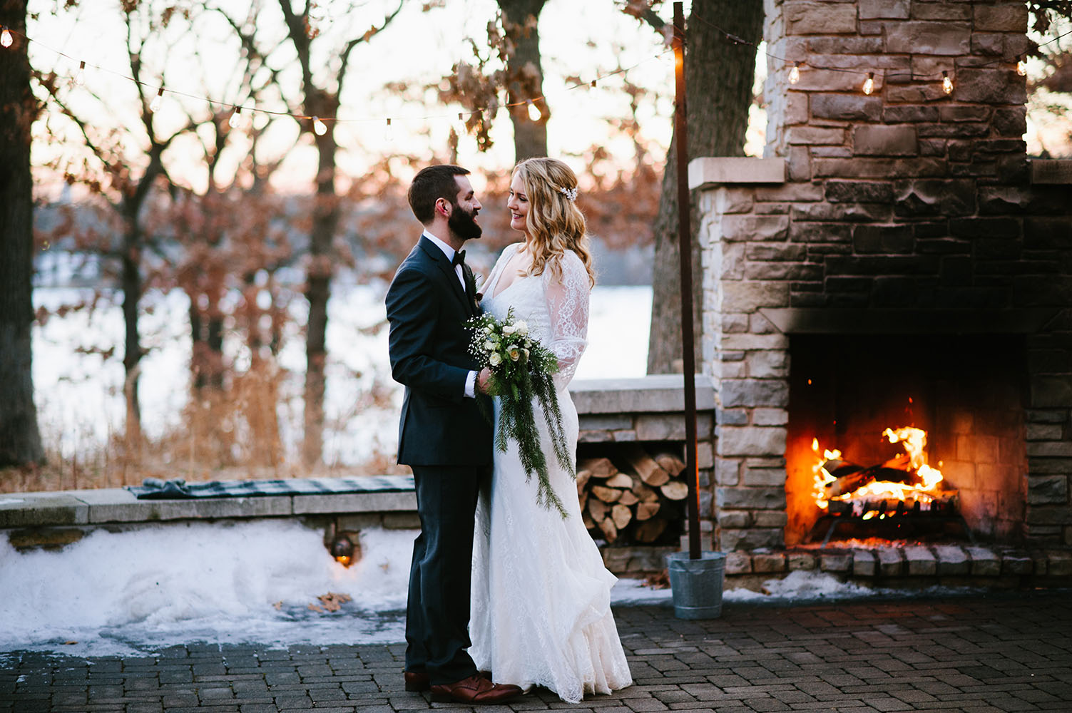 married couple by outdoor fireplace