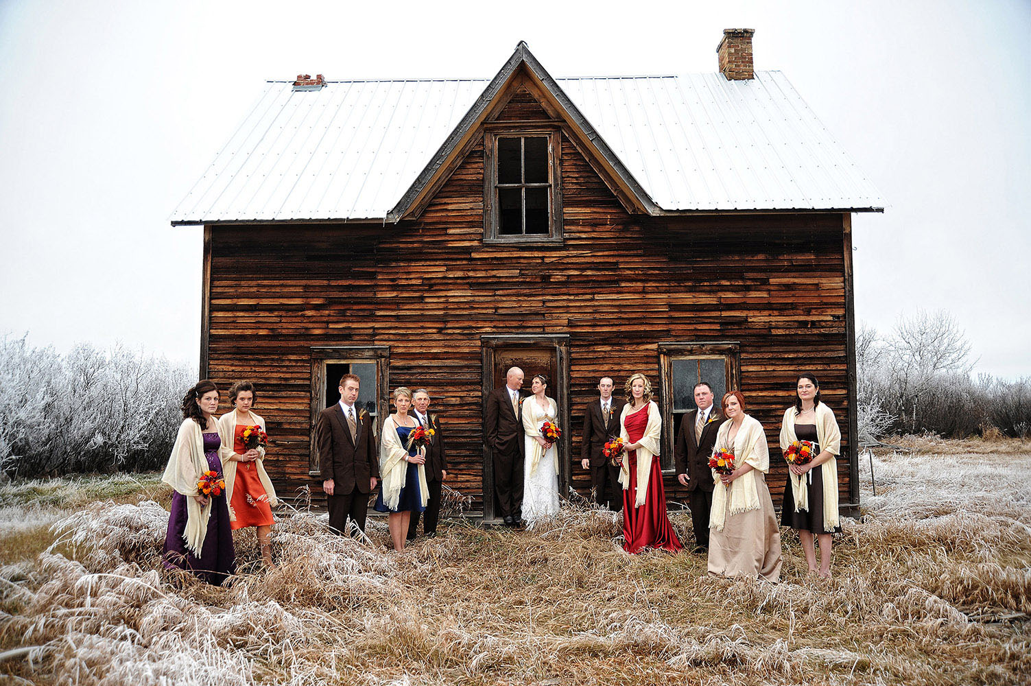 Wedding party in front of old cabin