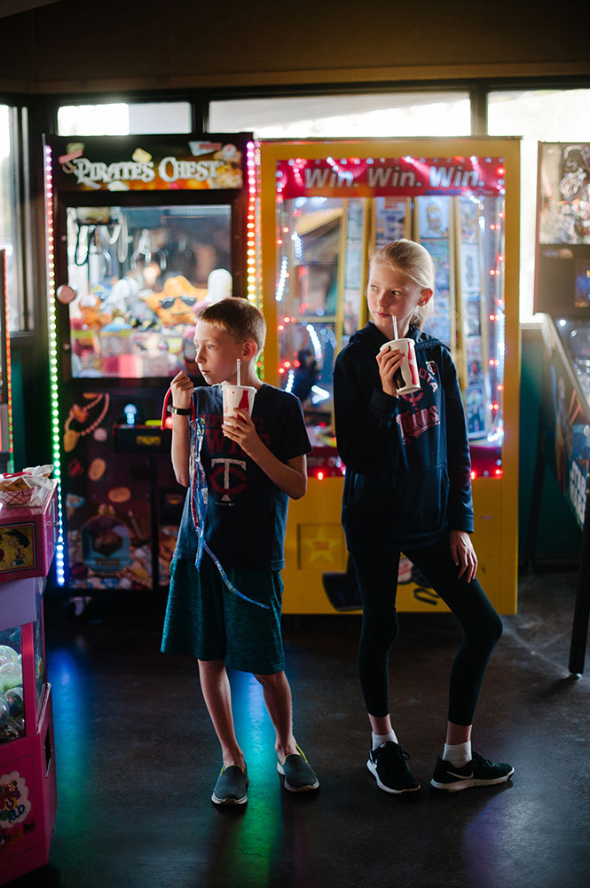 two kids at the arcade with soda