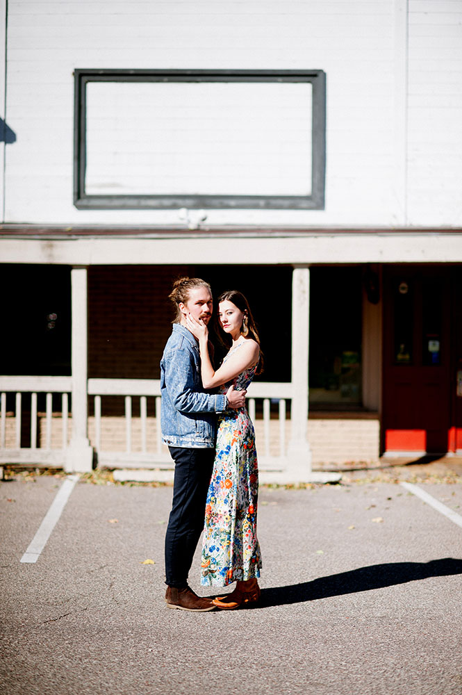 hipster guy in jean jacket girl with long floral dress in Western setting
