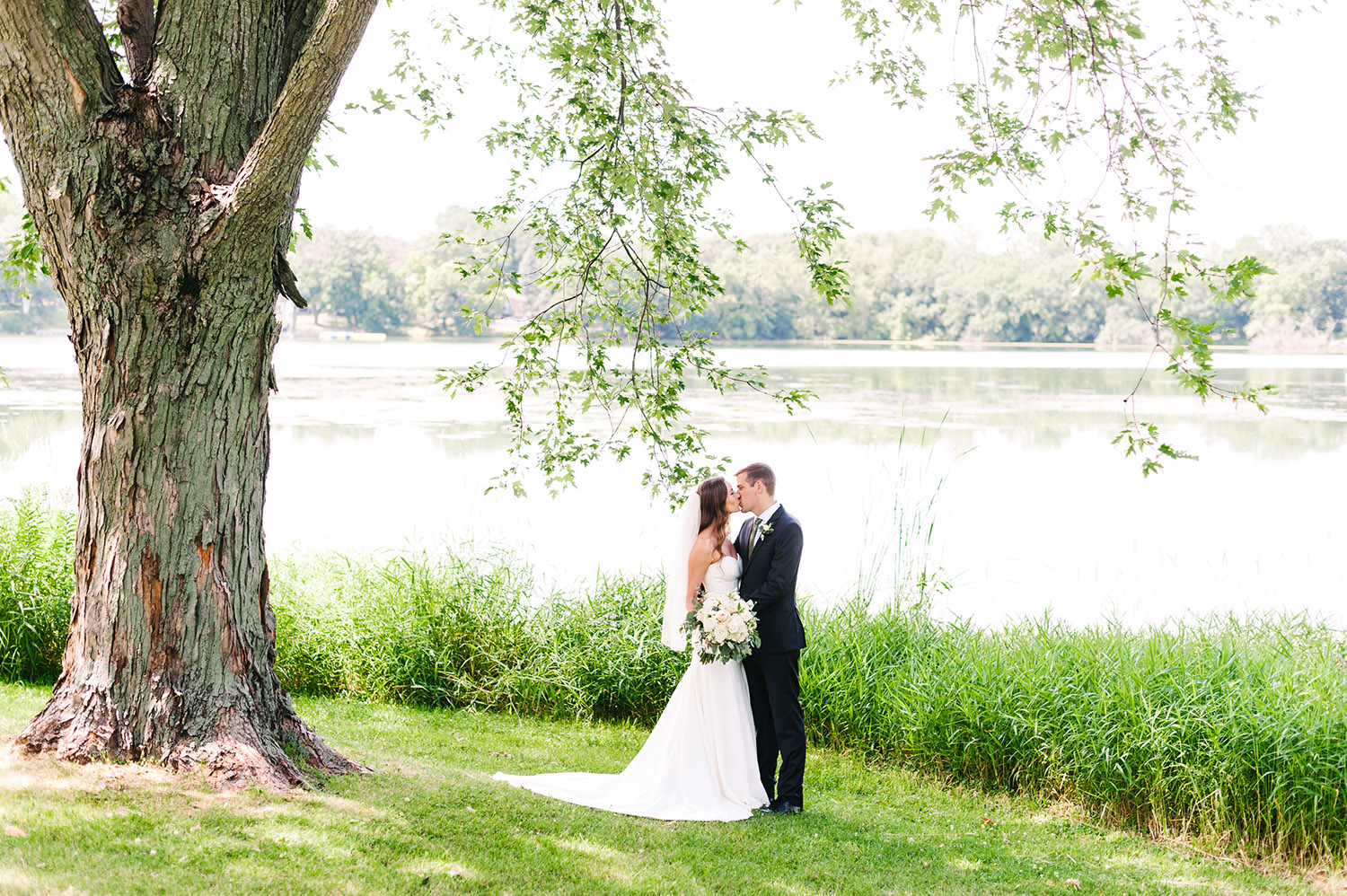 bride and groom in front of a lake