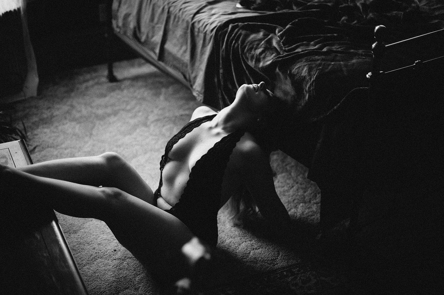 black and white woman on floor arching back in black lace