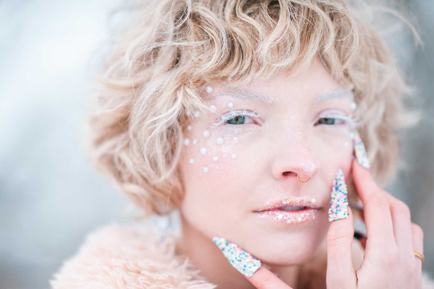 a white woman in the snow with blond hair and snowy makeup 