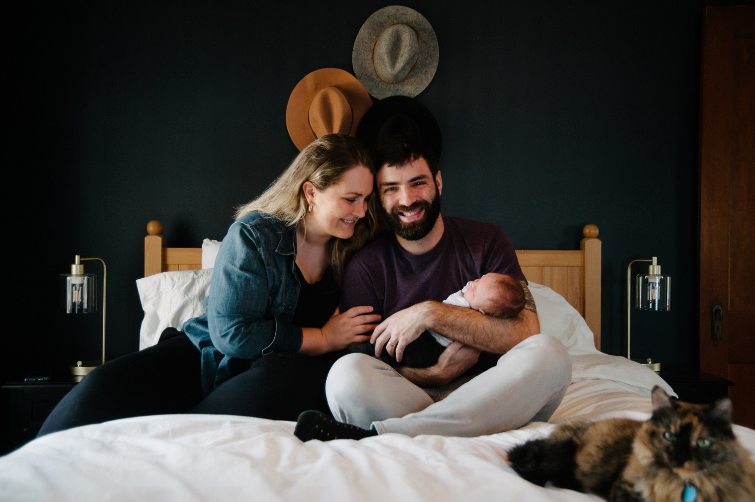 a white couple on their bed with a baby