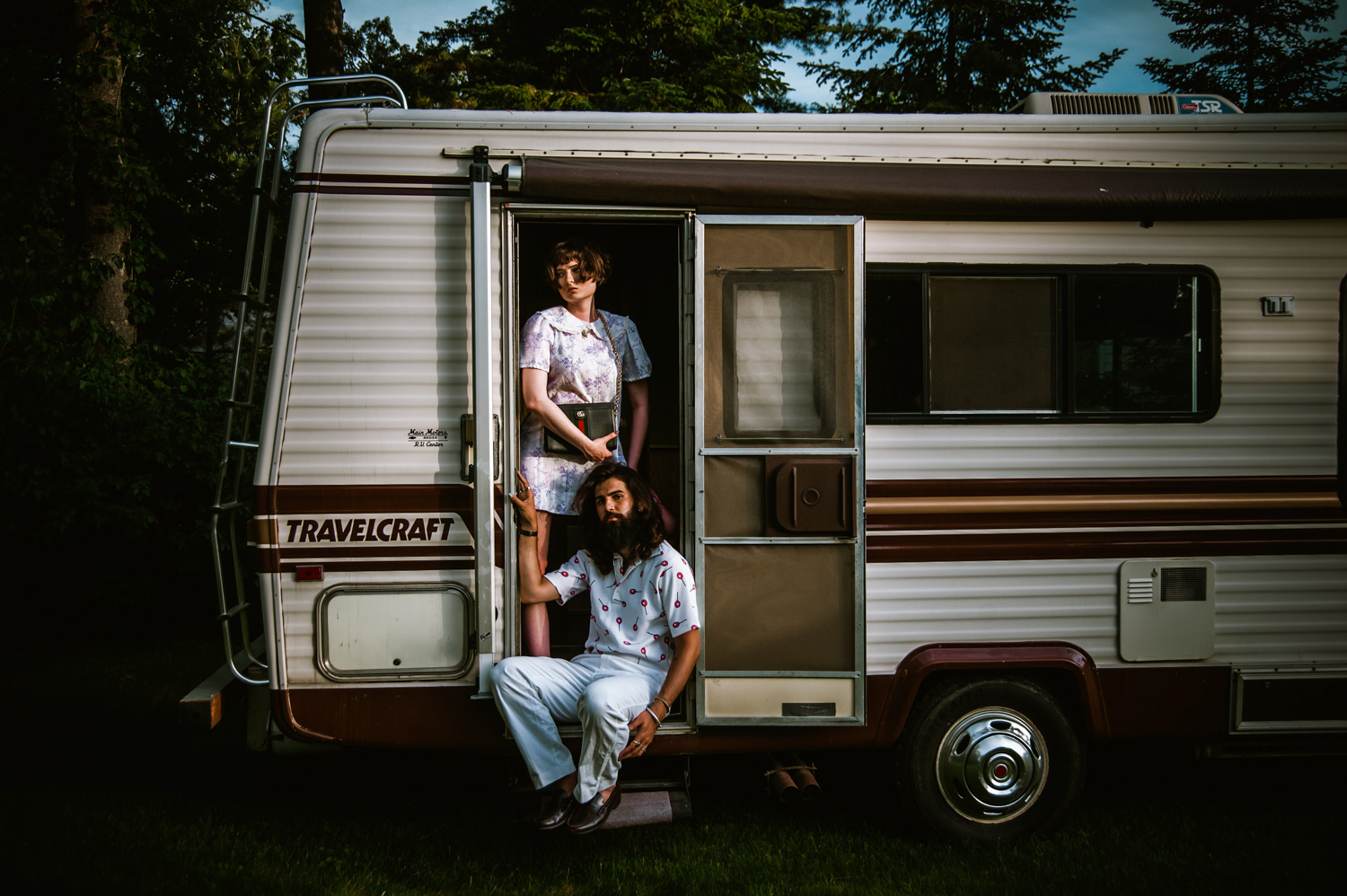 a white man and woman hanging outside an RV