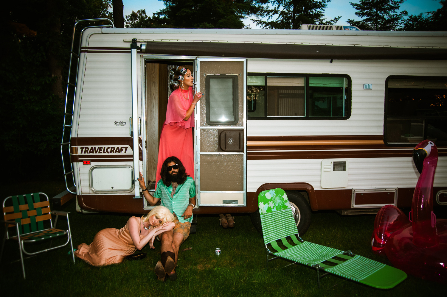 two white women and a white man hanging outside of an RV