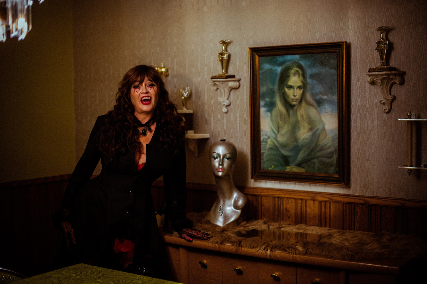 a woman vampire at Grandpas Pool House in front of a painting of a woman