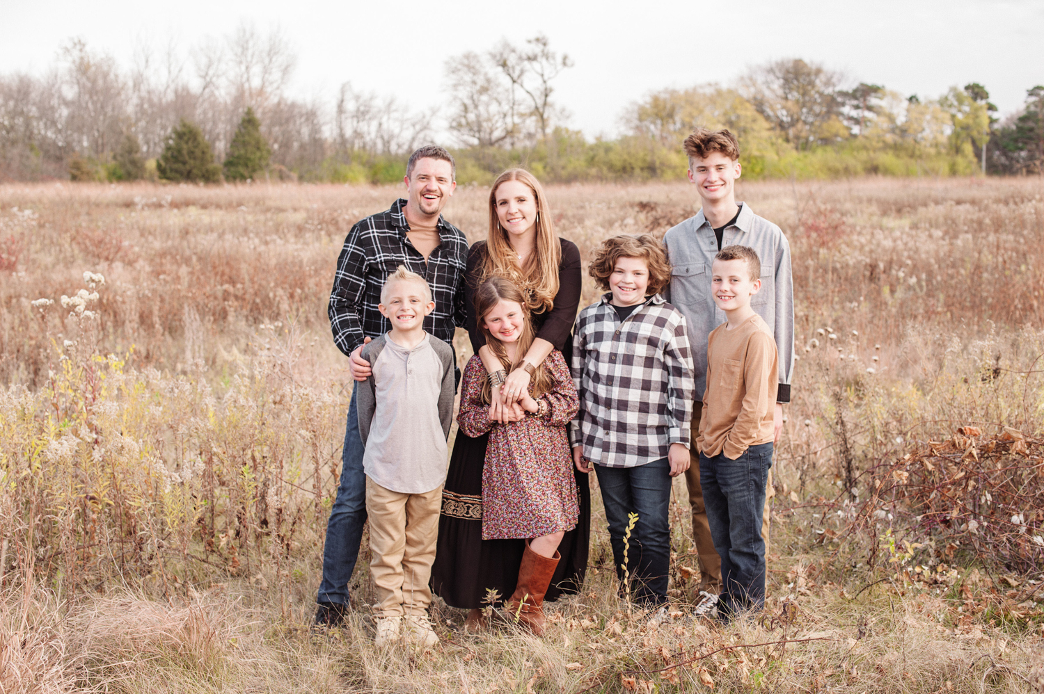 a Fall photo of a family of 7 in a prairie